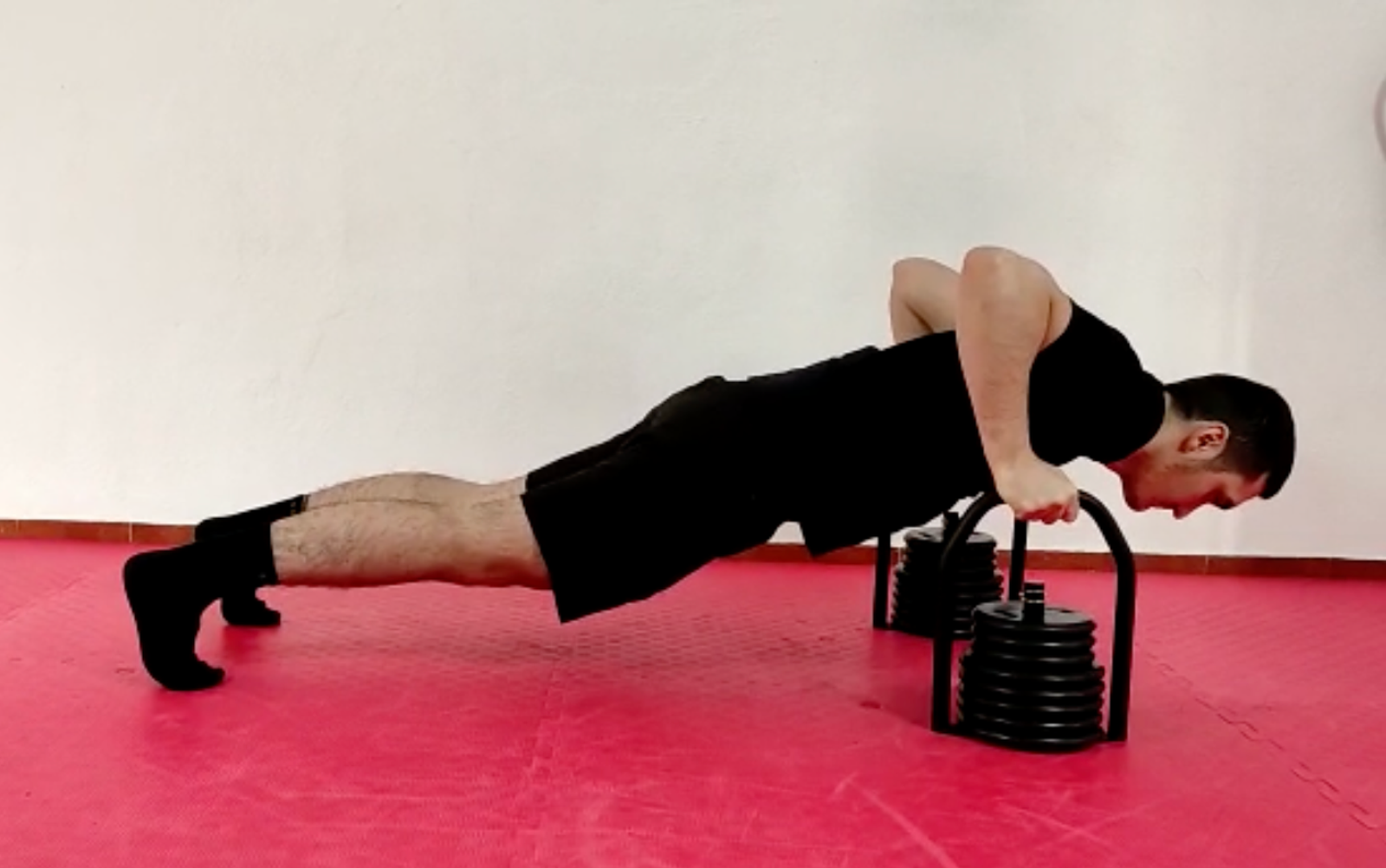 Push-up position using Regulabell kettlebell as handles
